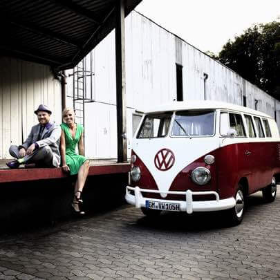 Ein Paar mit gemieteten Oldtimer VW Bulli beim Fotoshooting bei einer alter Fabrik